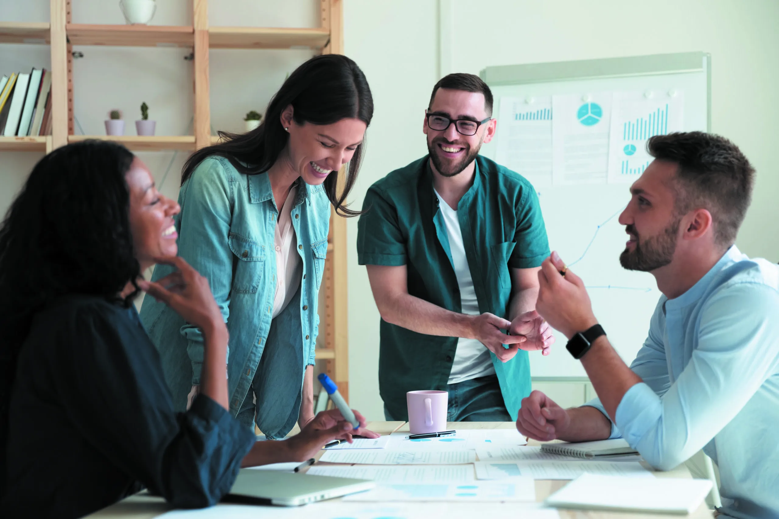 Smiling,diverse,colleagues,gather,in,boardroom,brainstorm,discuss,financial,statistics